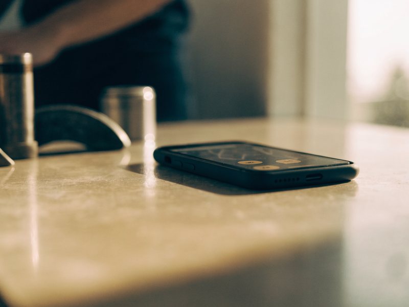 Smartphone mit eingehender Anfrage auf einer Werkbank im warmen Licht